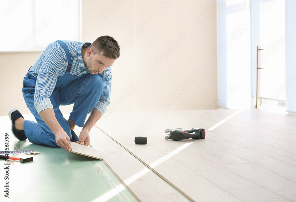 Male worker installing laminate flooring