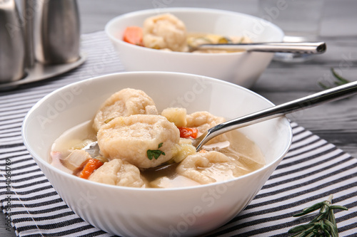 Portions of delicious chicken and dumplings on dining table