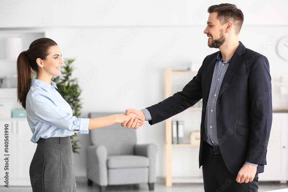 Manager and client shaking hands in office