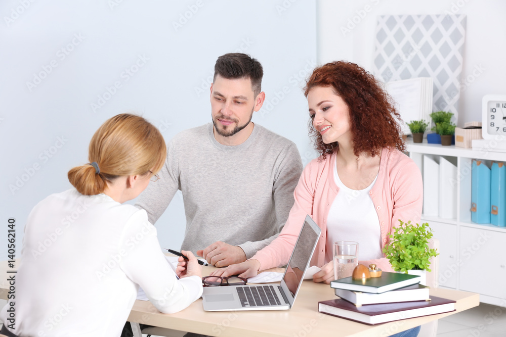Young couple signing contract at insurance agency office Young couple signing contract at insurance agency office