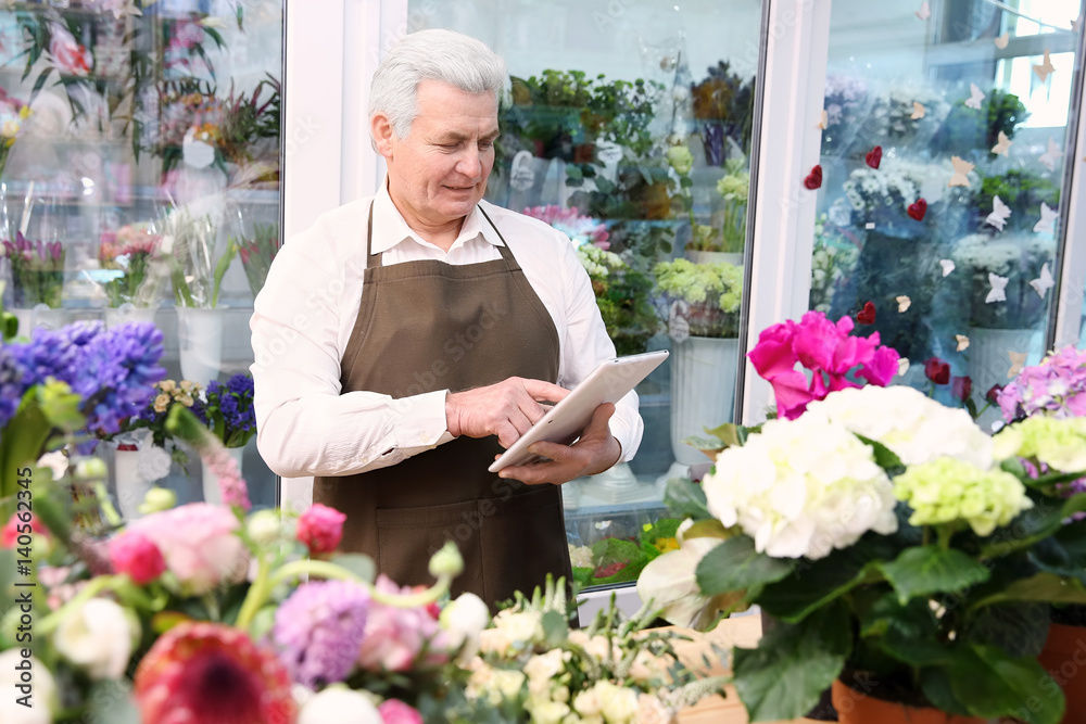 Male florist with tablet at flower shop Male florist with tablet at flower shop