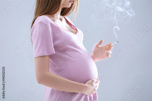 Pregnant woman smoking ciga...