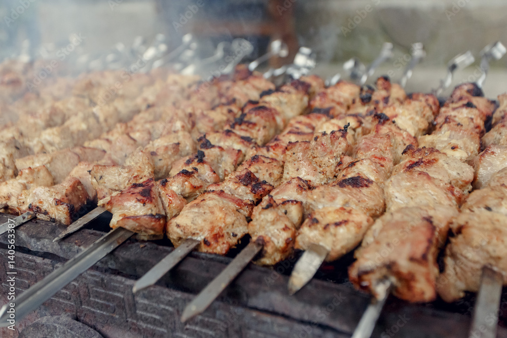 Marinated shashlik preparing on a barbecue grill over charcoal. Shashlik or Shish kebab popular in Eastern Europe. Shashlyk (skewered meat) was originally made of lamb.