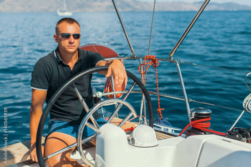 Obraz premium Man on his sailing yacht boat.