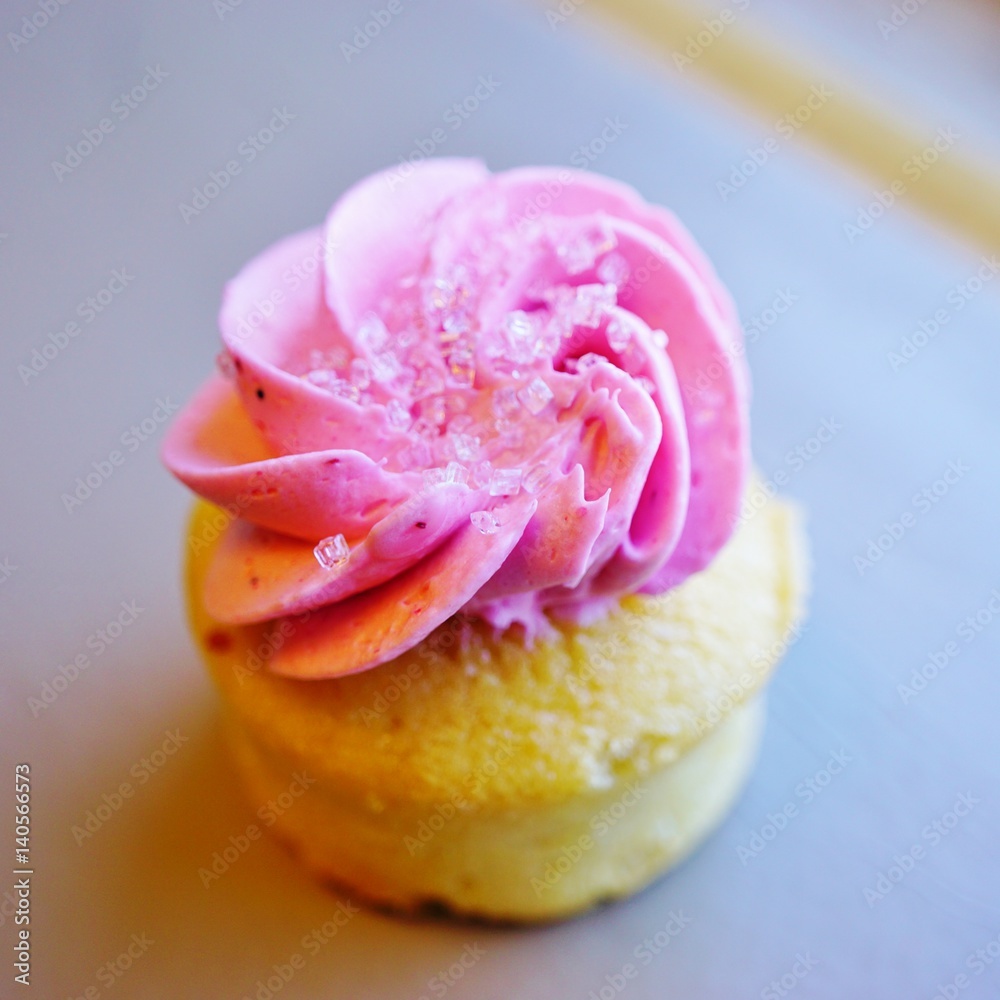 Mini cupcake with pink frosting and sanding sugar on top Mini cupcake with pink frosting and sanding sugar on top