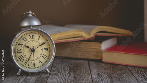 Roman Numeral in Vintage Alarm Clock and Open Book Background with Copy Space for Advertise about the Education or Nostalgia Concept