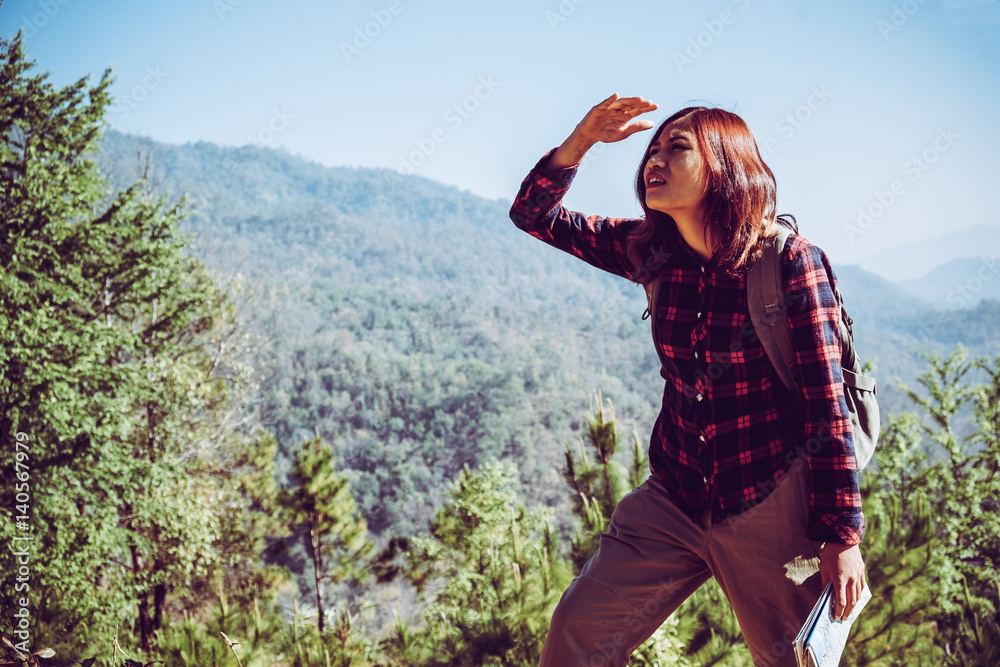 woman backpacker hiking on sunrise mountain peak cliff