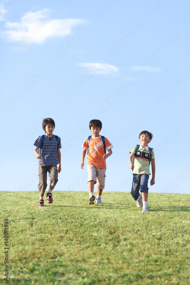 Schoolboys walking at riverbank, copy space