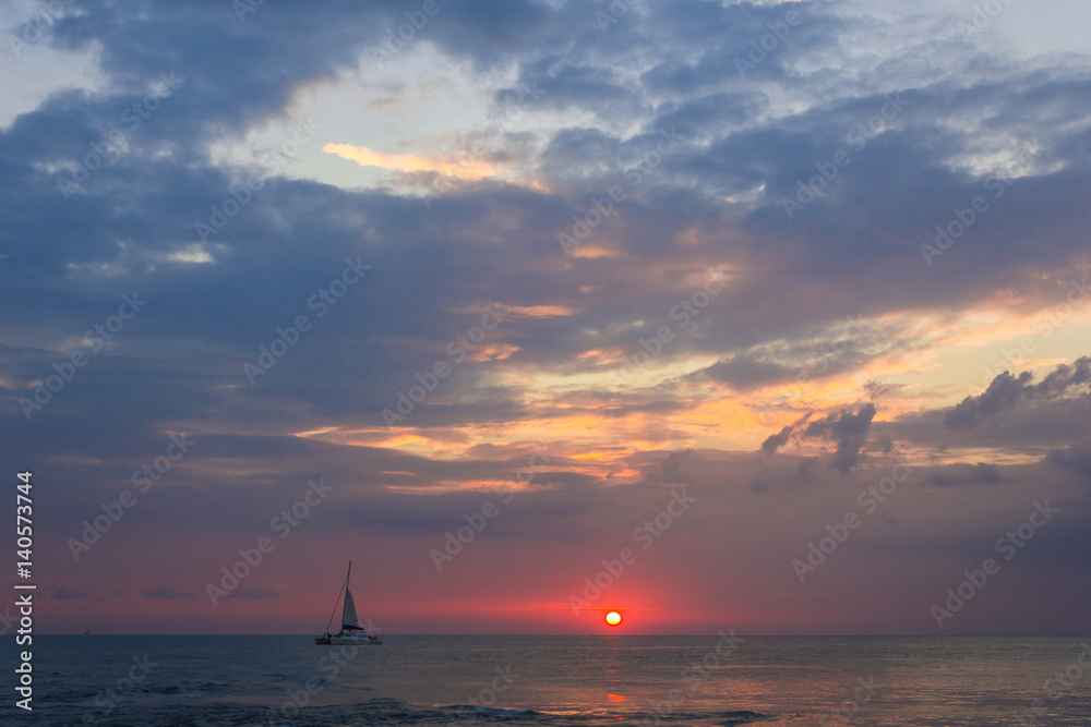The boat sailing in sunset. A yacht sailing in sunset lights. Horizontal outdoors shot.