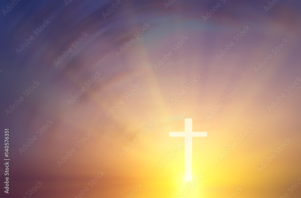 Conceptual religious composition in the form of a cross on a background of a blurry sunset with the rays of the sun.