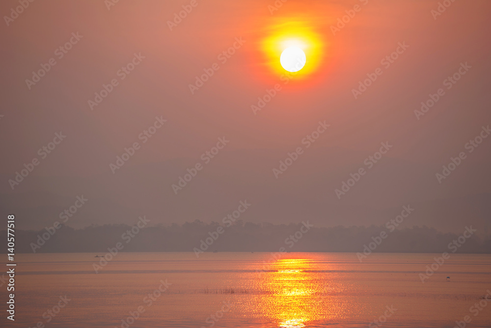 Sunrise over the lake with silhouette branch in foreground Sunrise over the lake with silhouette branch in foreground