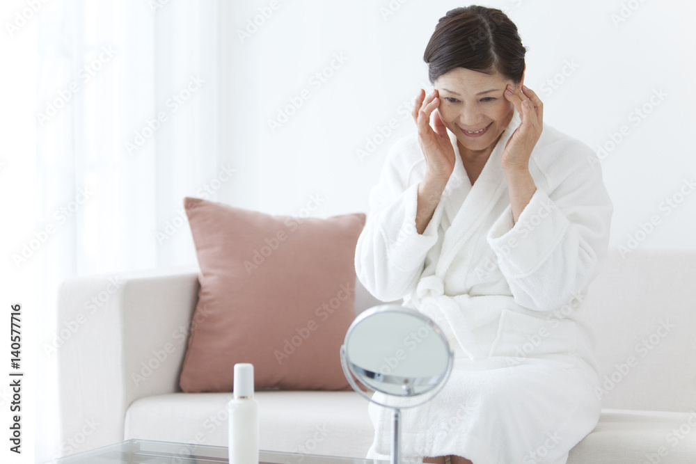 Middle-Aged Woman Wearing Bathrobe Using Skin Care Product