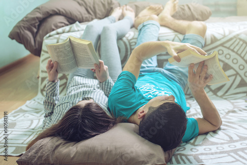 Couple lying on the floor and lifting legs nice reading