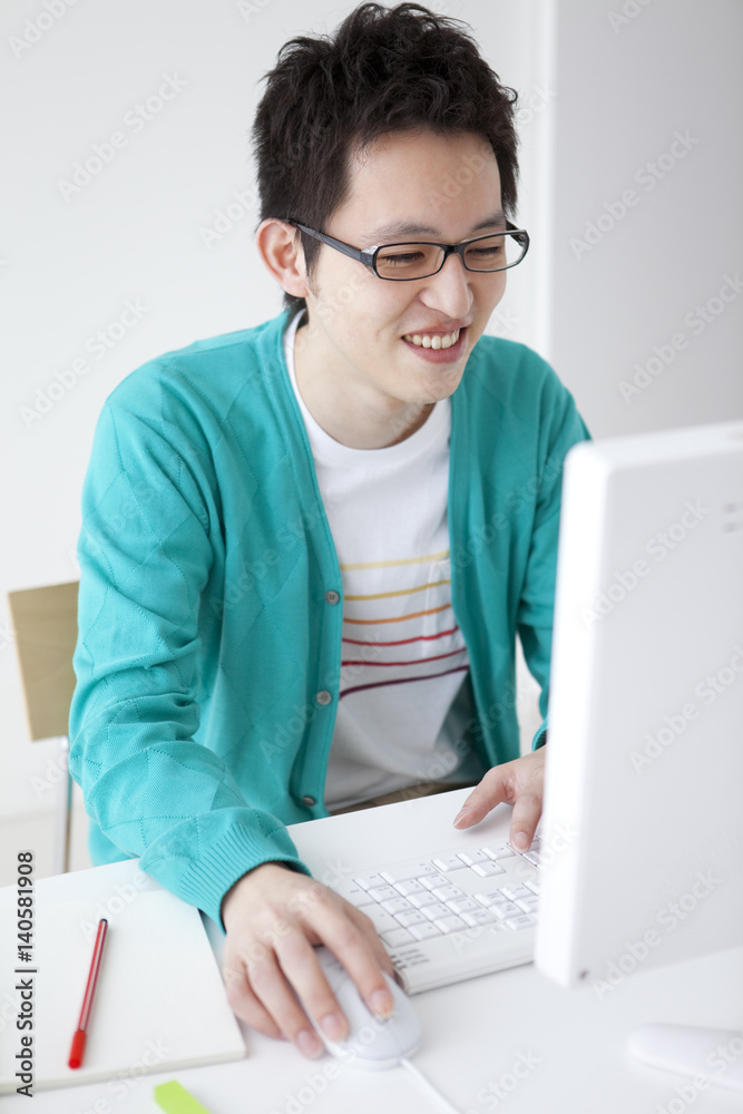 Young man using desktop PC Young man using desktop PC
