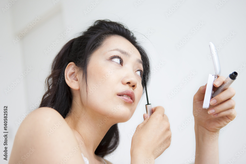 Woman applying mascara 