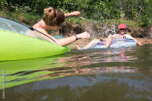 Obraz na płótnie Couple tubing down the river in the summer w salonie