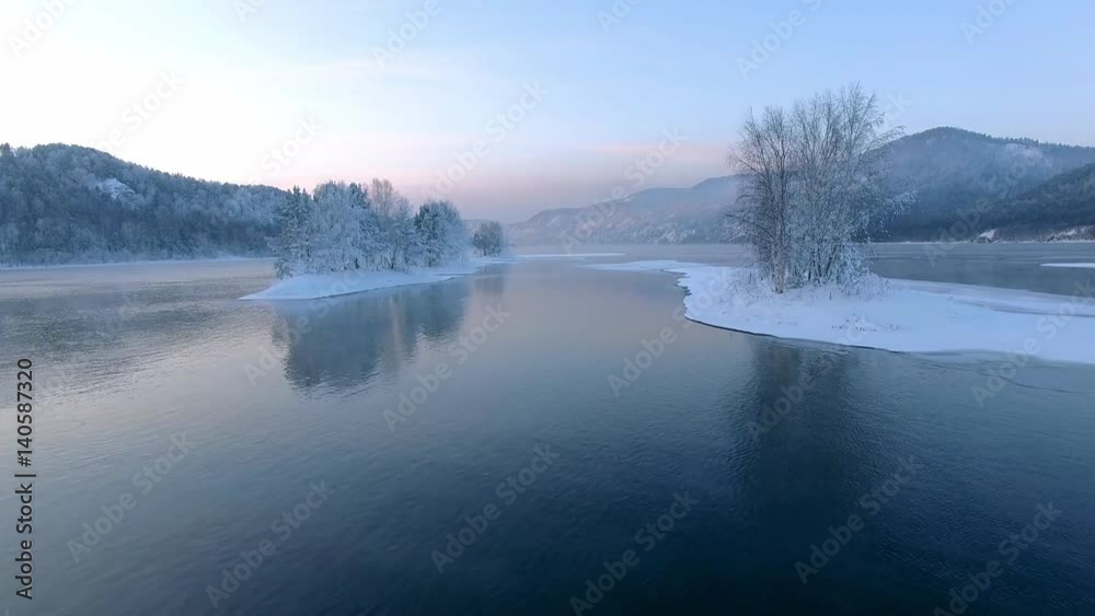 Beautiful winter landscape. Sunset on the river. Great Siberian river Yenisei. Aerial View.