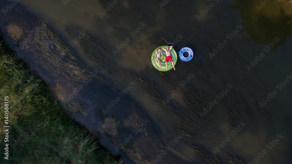 Aerial photo of a couple tubing down the river