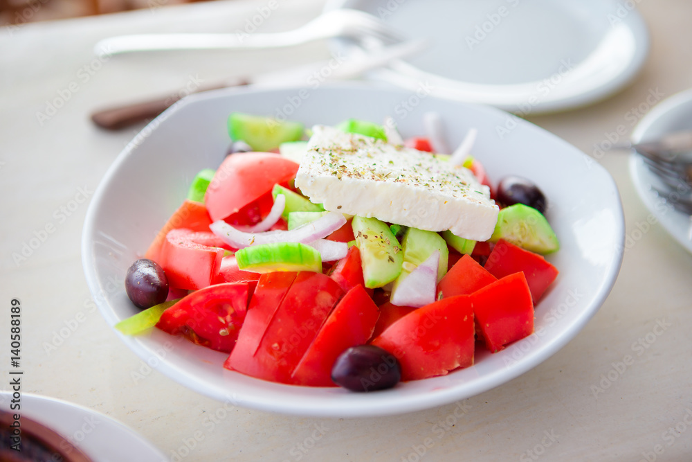 Traditional fresh greek salad, frappe and brusketa served for lunch at outdoor cafe