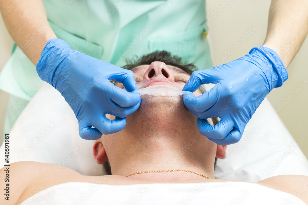 Man in the mask cosmetic procedure in spa salon Man in the mask cosmetic procedure in spa salon