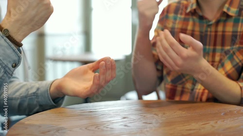 Men sitting in the cafe and playing a game called rock paper scissors, steadycam shot
