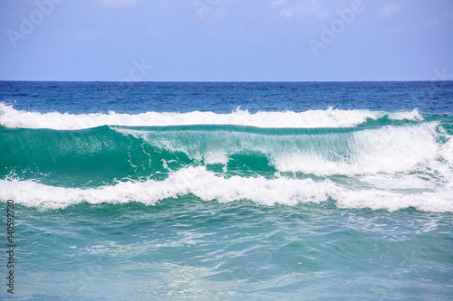 Breaking wave. Empty green wave rolls through to beach with no surfer in view photo