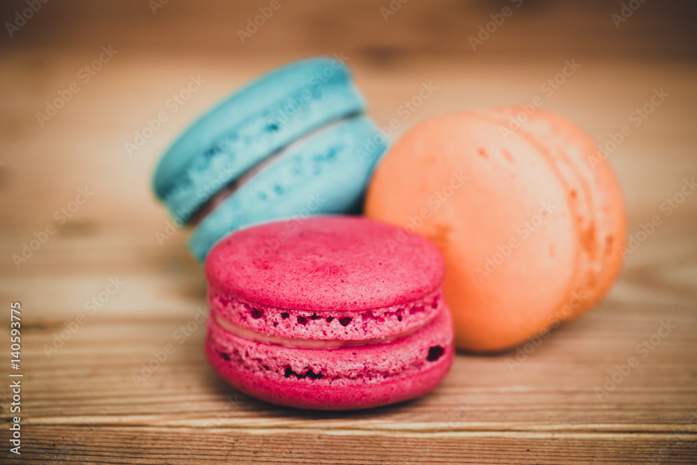 Fototapeta premium Macaron sweet dessert on wood background dark tone.