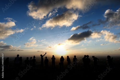  Silhouettes of tourist on the cliff when sunset at Korhong Hill in Hat Yai Thailand.