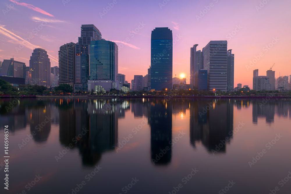 Bangkok city with park with reflection of skyline at sunrise, Thailand.