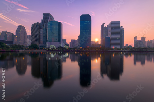 Bangkok city with park with reflection of skyline at sunrise, Thailand. © yotrakbutda