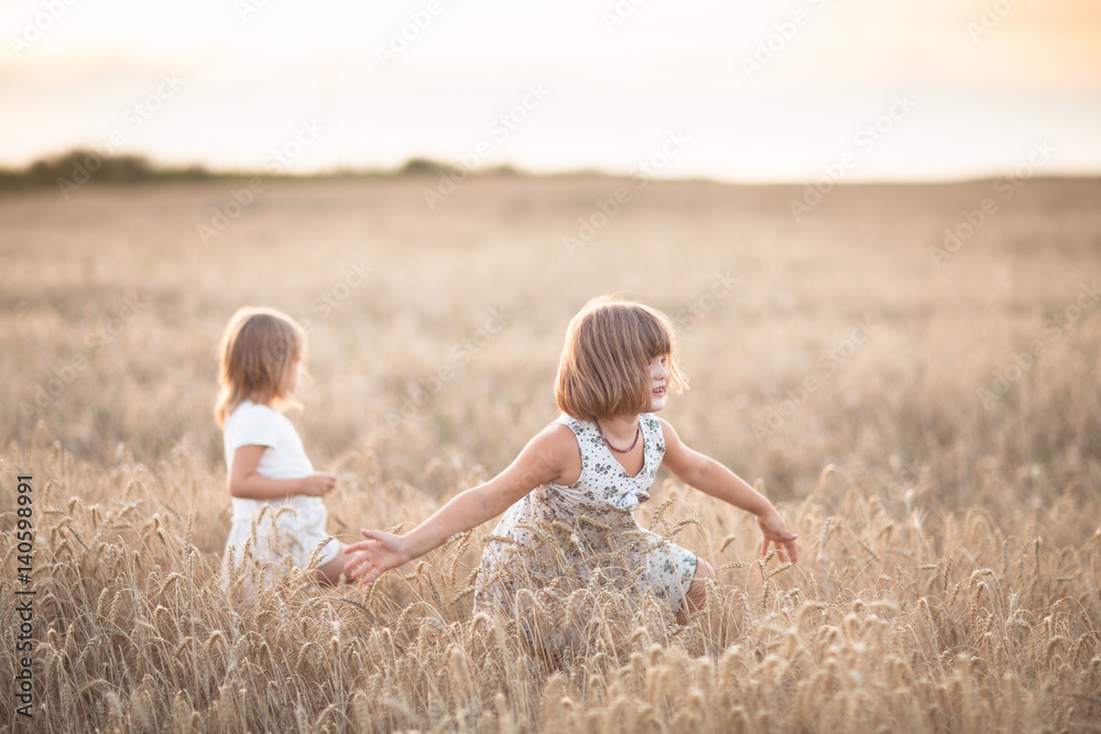 Fototapeta premium Two emotional sisters girls dance at sunset