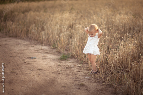 Kid toddler on wheat field at sunset, lifestyle © natalialeb