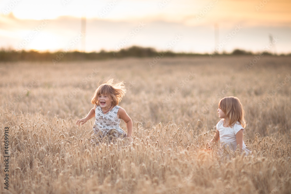 Fototapeta premium Two emotional sisters girls dance at sunset
