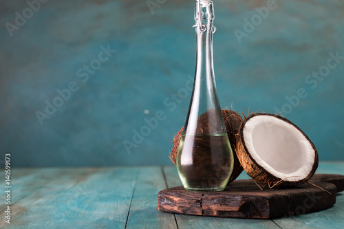 coconut oil and fresh coconuts on old wooden table