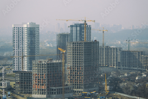 Several new high building construction with many yellow cranes