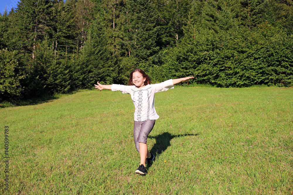 happy little girl running on green field