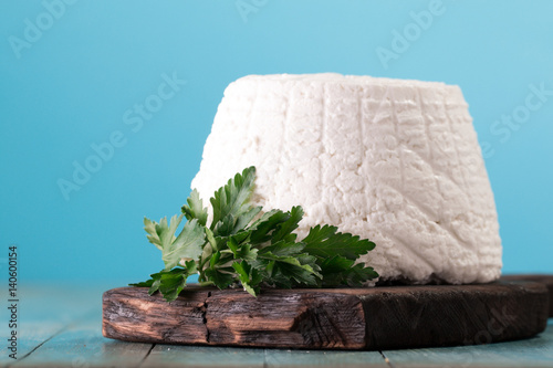 A fresh ricotta cheese with parsley leaf on wooden table, italian food