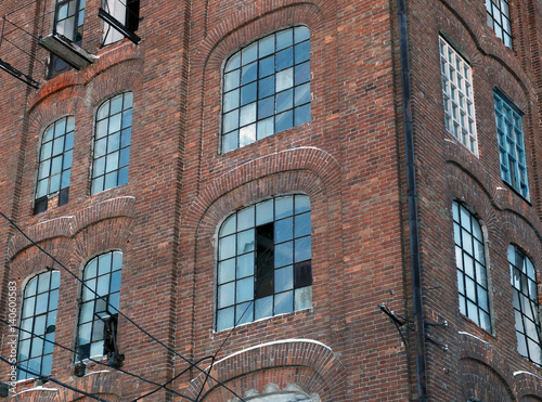 The red brick wall of the old factory with broken windows  photo