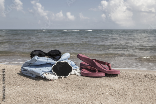 Summer background with flipflops and sunglasses on beach
