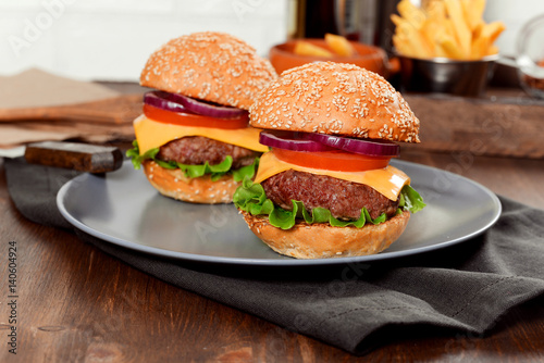 Cheeseburgers on wooden table with copy space