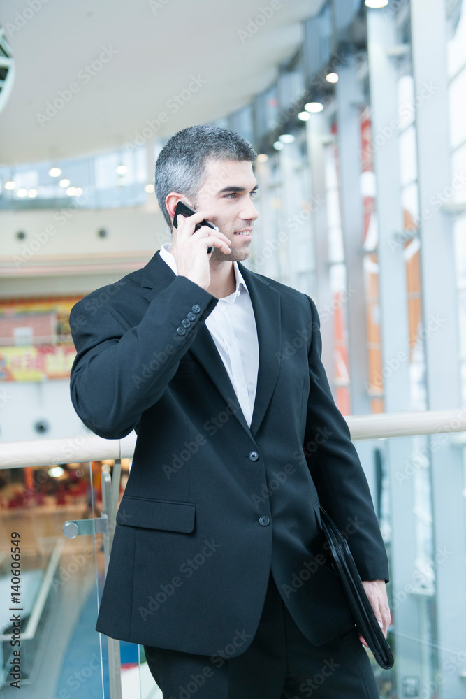 Businessman walking and talking on mobile phone