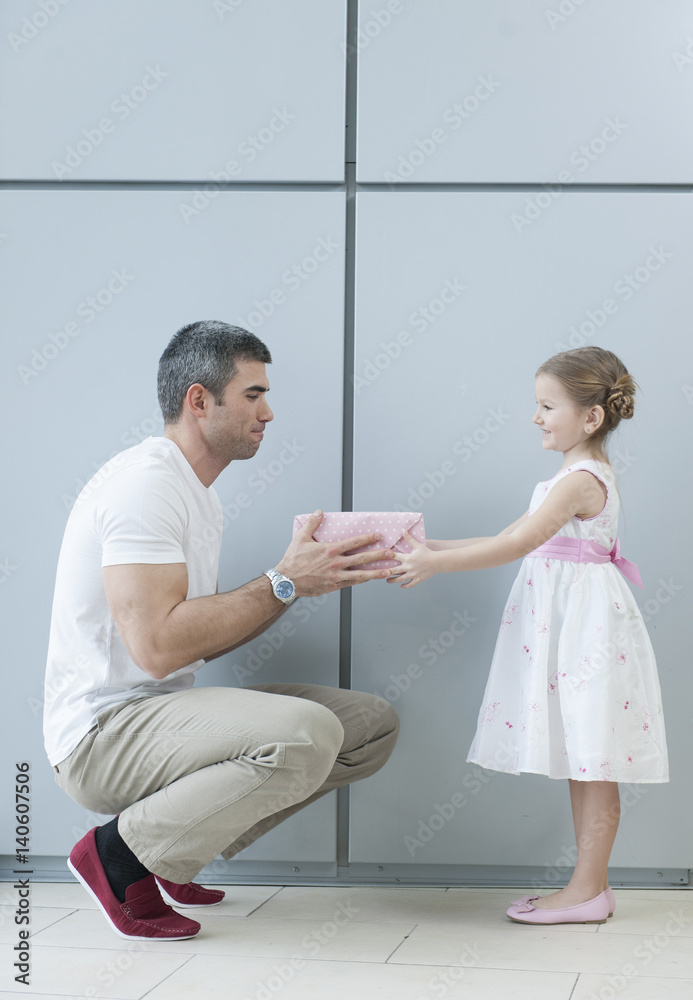 Young girl handing present to her father Young girl handing present to her father