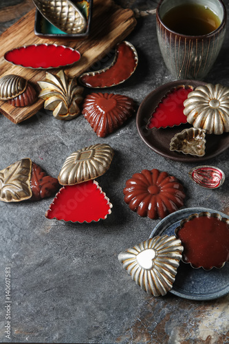 Chocolate and berry pudding in metal molds. Dark background.
