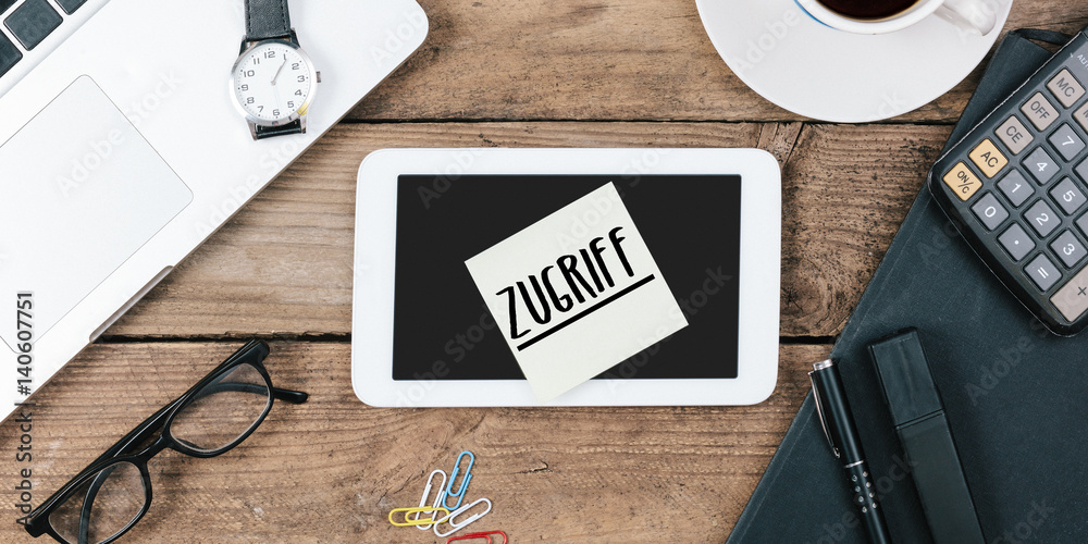 Naklejka premium Zugriff, German text for Access , yellow sticky note, office desk with computer technology, high angle