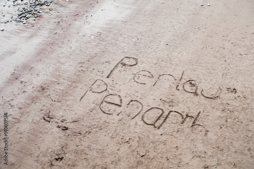 The name of Penarth Town written in English and Welsh into the sand of Penarth beach. photo