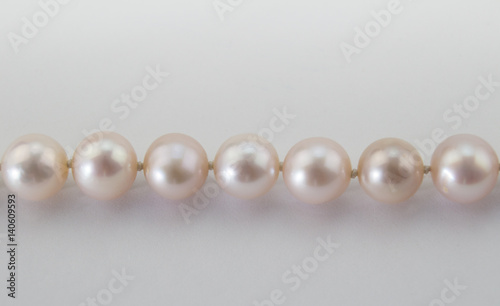Pink pearl necklace close up on white background