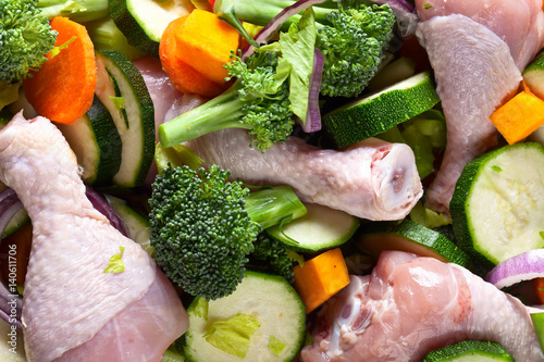 raw vegetables with chicken drumsticks, top view