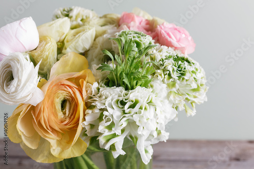 Luxury bouquet of different flowers in glass vase on wooden wall. Copy space