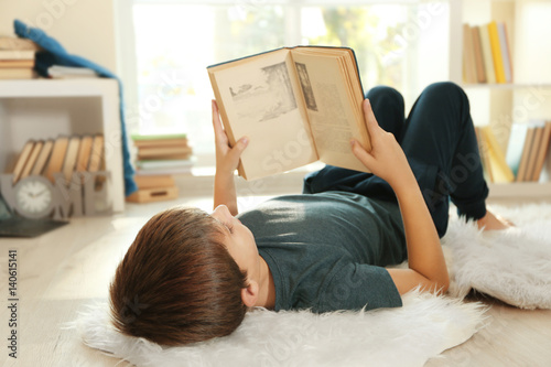 Cute schoolboy with book on...