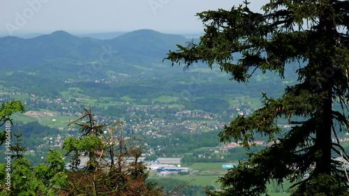 A vast rural area - a mountainious landscape in the background, tree crowns in the foreground photo